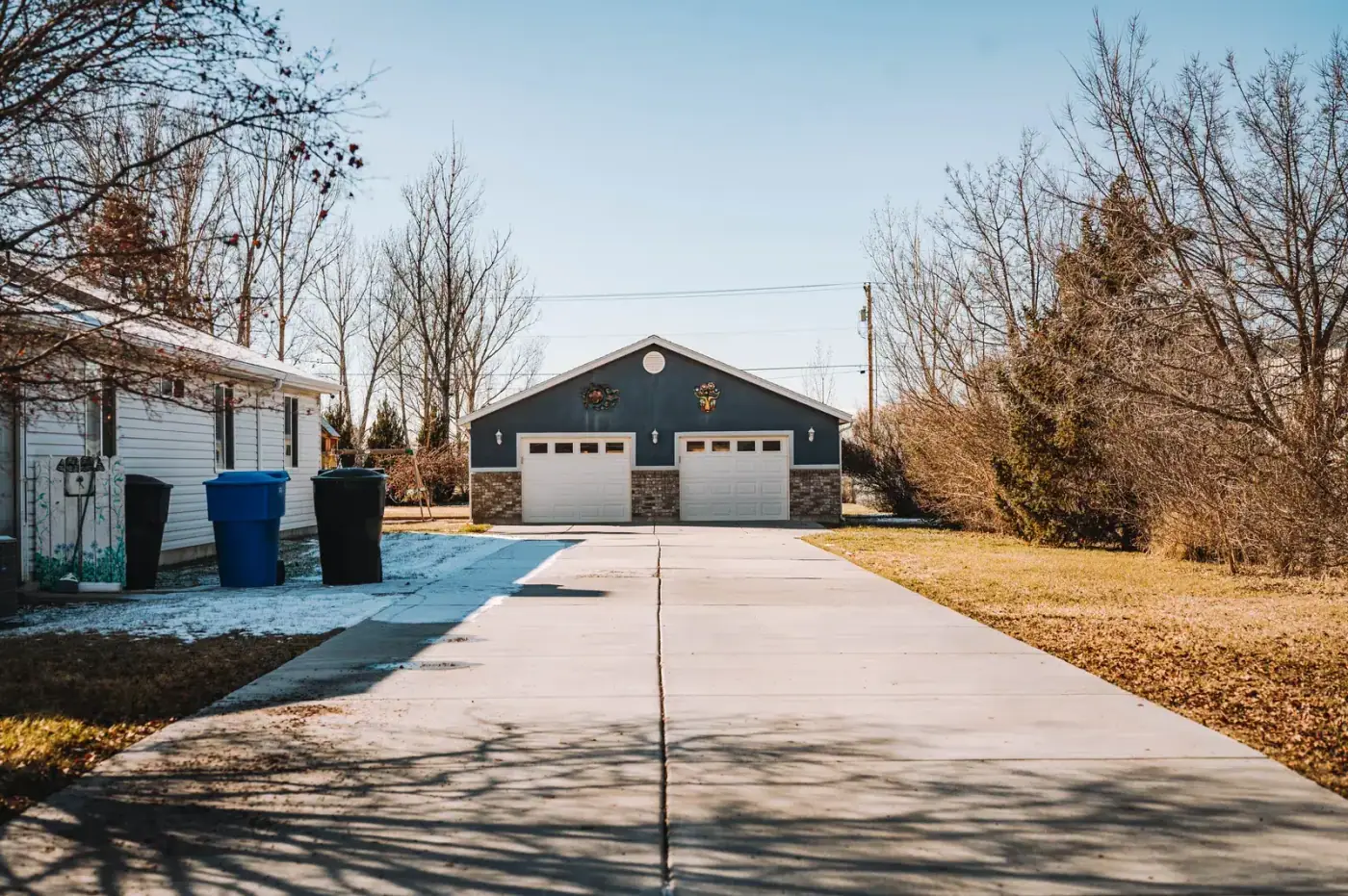 Long concrete drive running back to a detached garage on a country lot