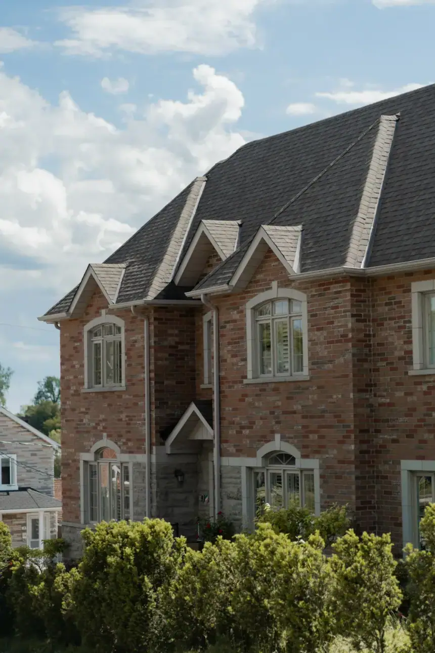 Brick house with gables and trimmed windows seen from the yard