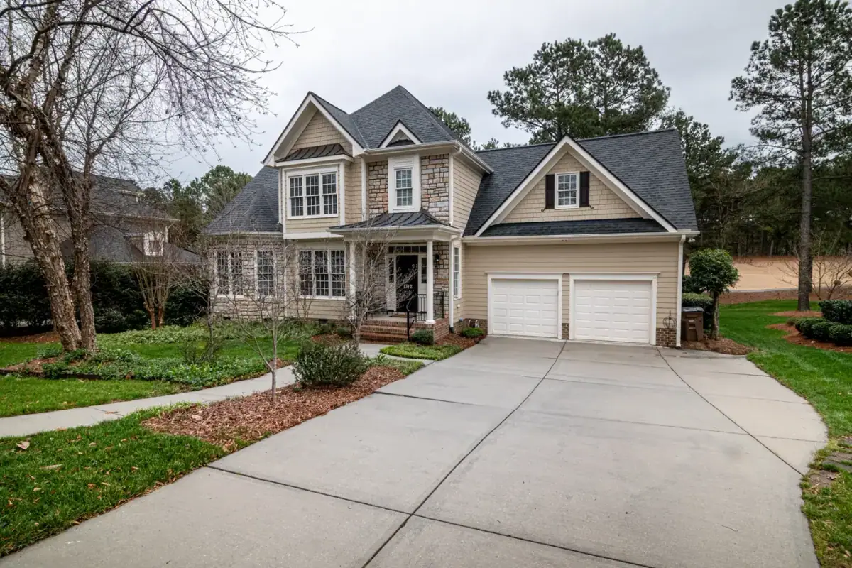 Suburban home with a clean, bright concrete driveway running to the garage